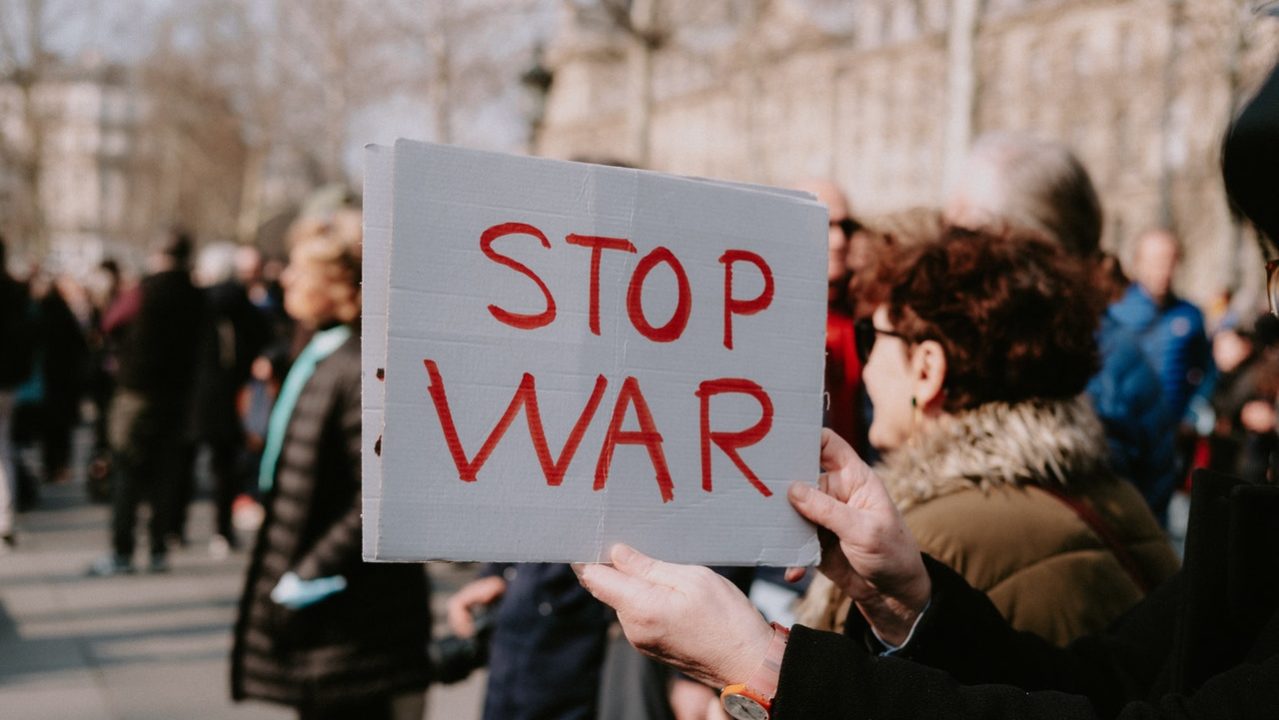 Manifestante exibe cartaz com os dizeres "stop war" ("pare a guerra")