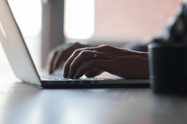 mãos de mulher teclam em computador