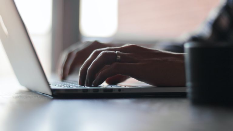 mãos de mulher teclam em computador