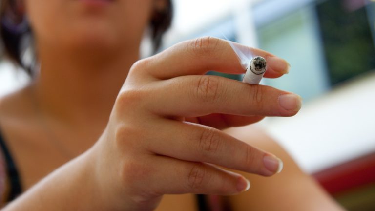 adolescente com cigarro na mão