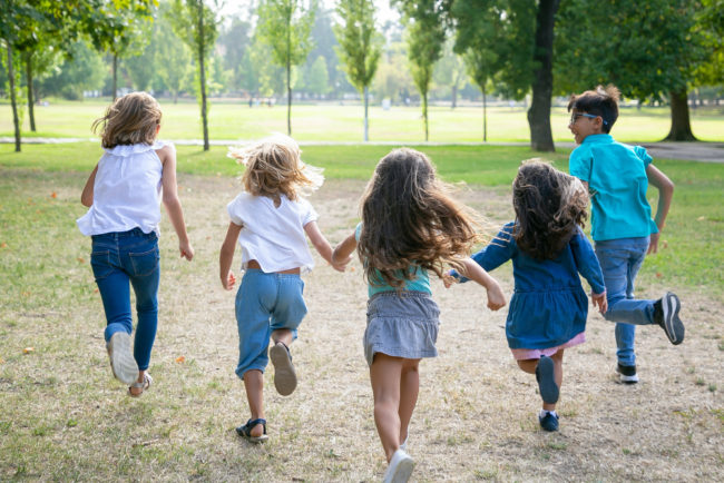 grupo-de-criancas-correndo-na-grama-juntos-tendo-uma-corrida-no-parque-vista-traseira-comprimento-total-conceito-de-atividade-infantil-ao-ar-livre