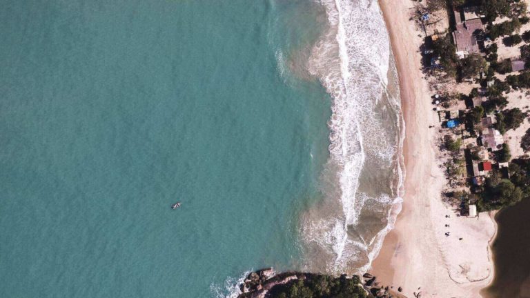litoral-paulista vista panorâmica de praia; ondas avançam sobre faixa de areia