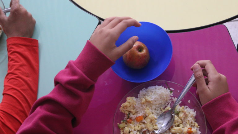 Programa Nacional de Alimentação Escolar: criança come merenda em escola pública