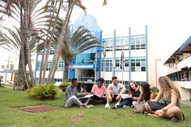 Imagem do WhatsApp de 2025-05-19 à(s) 16.29.19_21e6f3f5 Grupo de estudantes sentados em círculo na área externa da Unifal-MG, em momento de estudo e conversa.