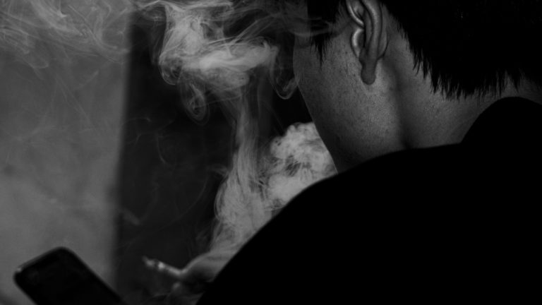 pexels-vape Jovem usando cigarro eletrônico, envolto em fumaça, ilustra preocupação crescente com a saúde vocal e respiratória entre brasileiros.