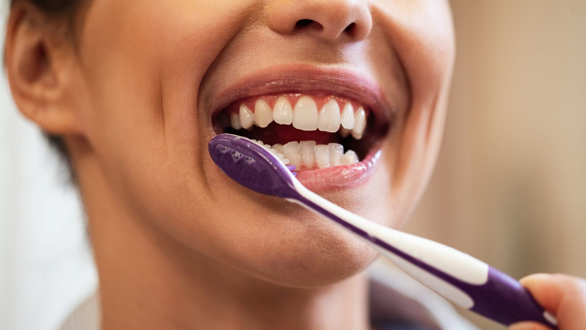 Close da boca de uma mulher escovando os dentes